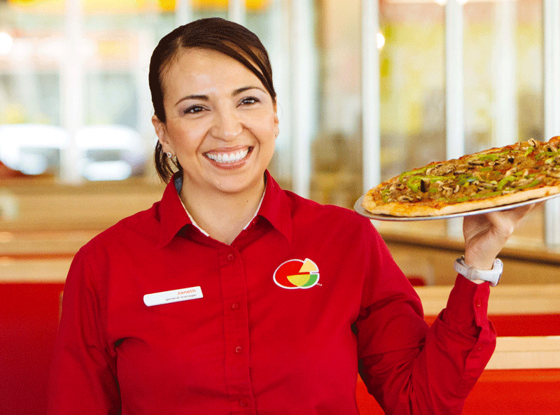 Peter Piper Pizza Female server in red shirt, carrying a pizza.